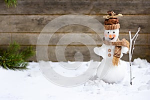 Snowman with a broom on a wooden gray background